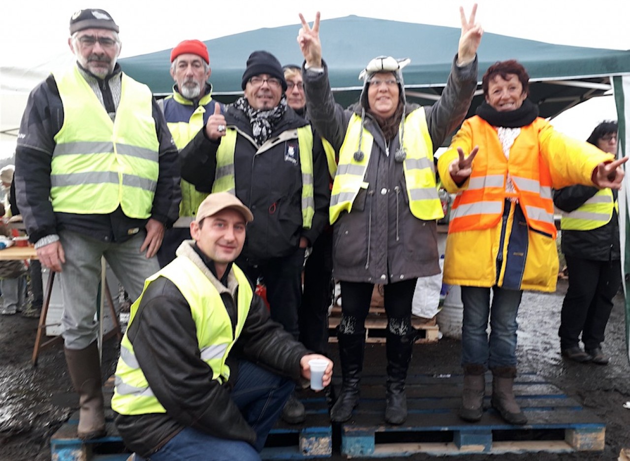 Pierre-Gaël Laveder (accroupi) avec des Gilets Jaunes de l'échangeur du Magny, sur la RCEA à Montceau-les-Mines, en Saône-et-Loire.