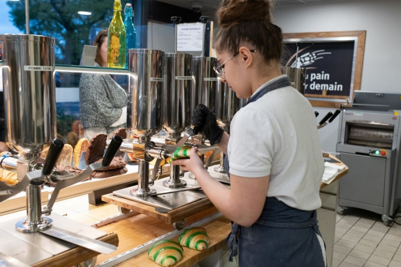 Dans le magains Du Pain pour demain, la boulangère remplit le croissant d'un fourrage au parfum framboise. © Sabrina Dolidze